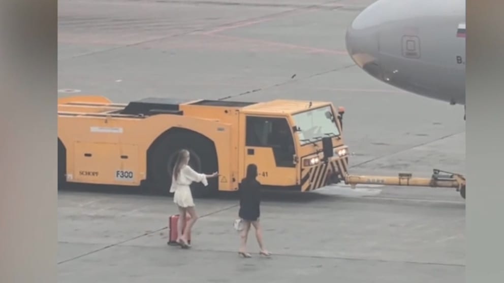 Frauen jagen Flugzeug auf Moskauer Rollfeld